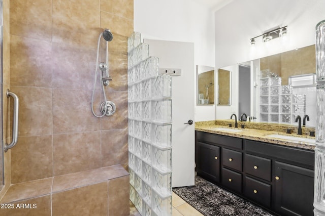 bathroom with a walk in shower, double vanity, and tile patterned floors