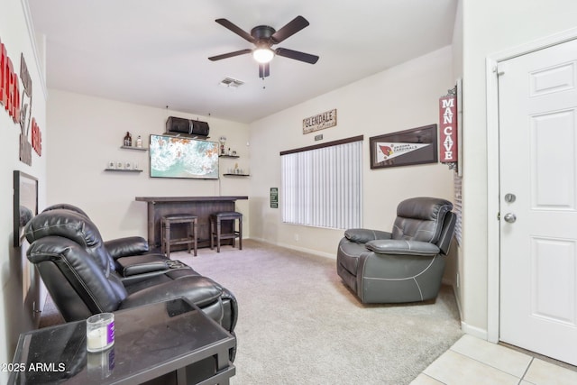 carpeted living area with a ceiling fan and baseboards