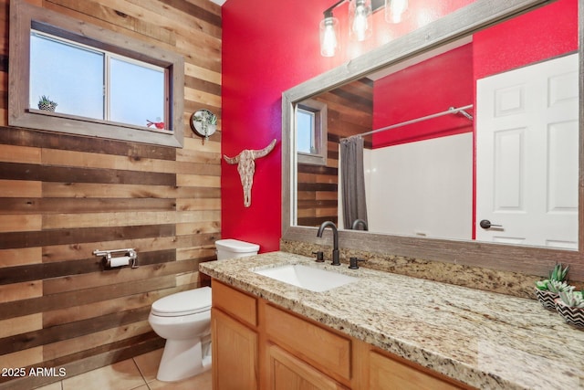 bathroom with wood walls, toilet, tile patterned floors, vanity, and a shower with curtain