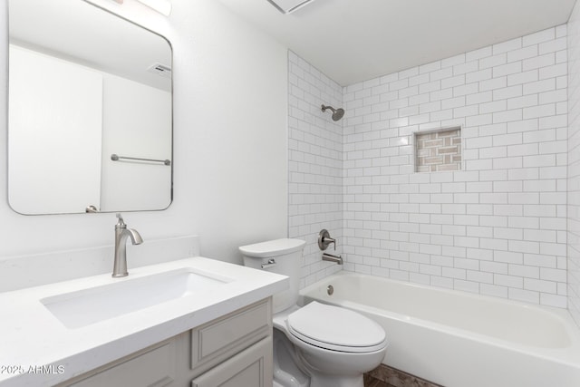 full bathroom featuring tiled shower / bath combo, vanity, and toilet