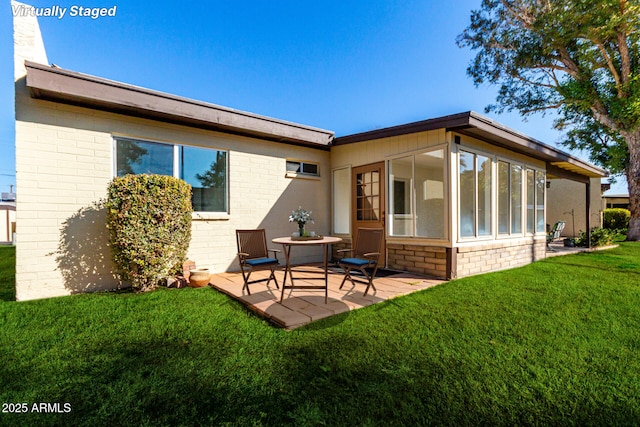 back of house featuring a patio area and a lawn