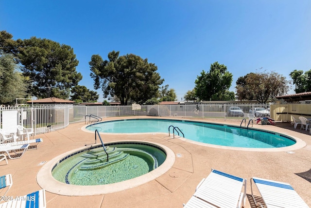 view of pool with a hot tub and a patio