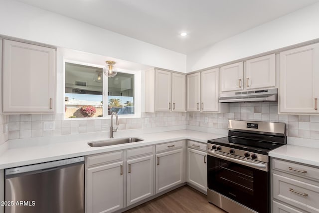 kitchen with sink, backsplash, dark wood-type flooring, and appliances with stainless steel finishes