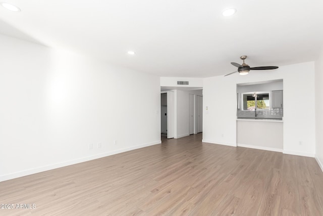 unfurnished living room featuring ceiling fan and light wood-type flooring