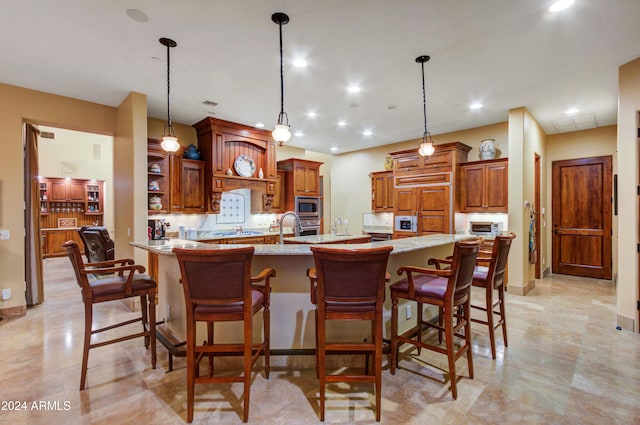 kitchen featuring light stone countertops, stainless steel appliances, a spacious island, pendant lighting, and a breakfast bar