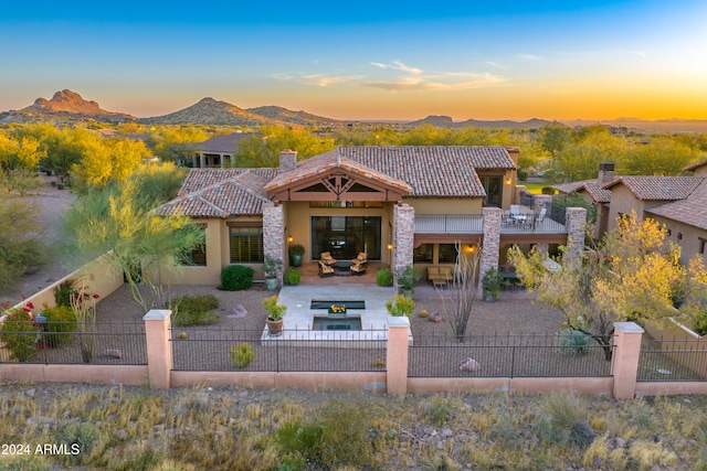 view of front of property with a mountain view, an outdoor living space, and a patio