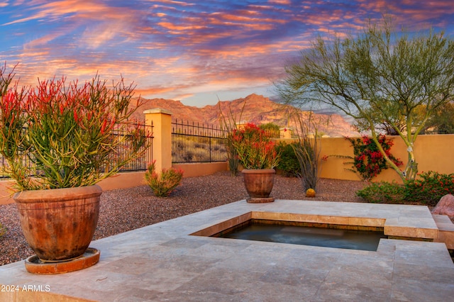 patio terrace at dusk featuring a mountain view