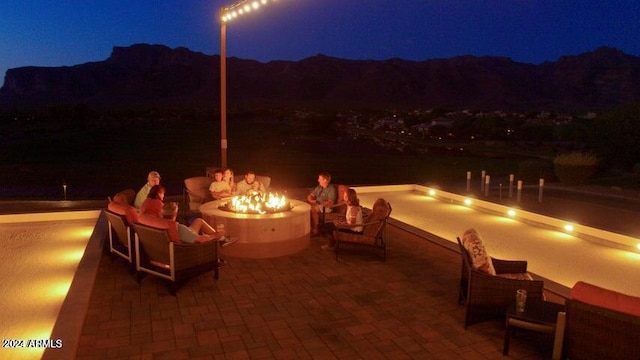 patio at night with a mountain view and a fire pit