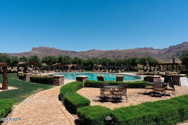 view of swimming pool featuring a mountain view and a patio