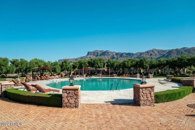 view of swimming pool with a patio area and a mountain view