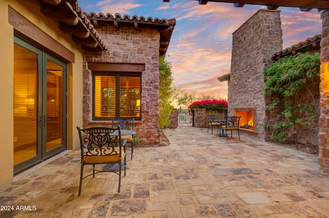 patio terrace at dusk with an outdoor stone fireplace