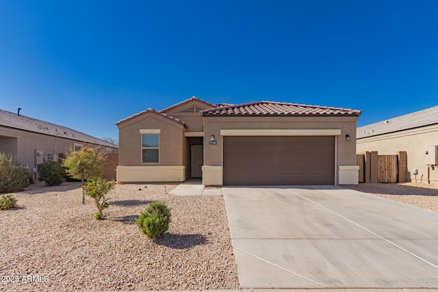 mediterranean / spanish home featuring stucco siding, a tiled roof, an attached garage, and concrete driveway