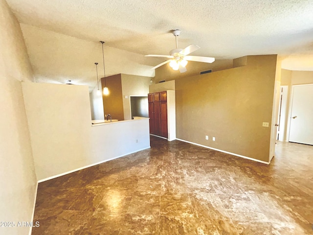 spare room with a textured ceiling, ceiling fan, and vaulted ceiling