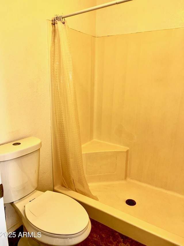 bathroom with toilet and walk in shower