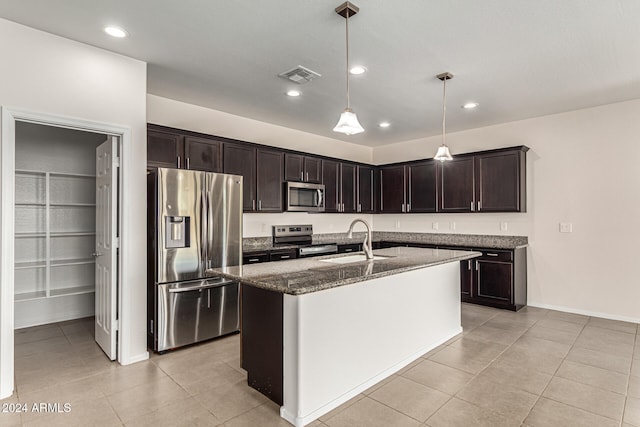 kitchen featuring hanging light fixtures, a kitchen island with sink, sink, dark brown cabinetry, and stainless steel appliances