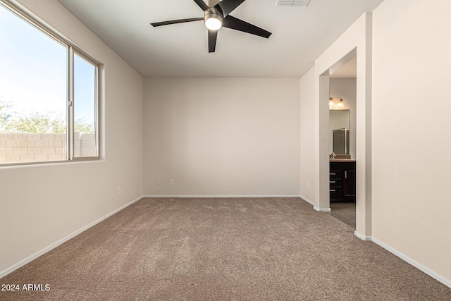 unfurnished bedroom featuring baseboards, visible vents, ensuite bathroom, and carpet