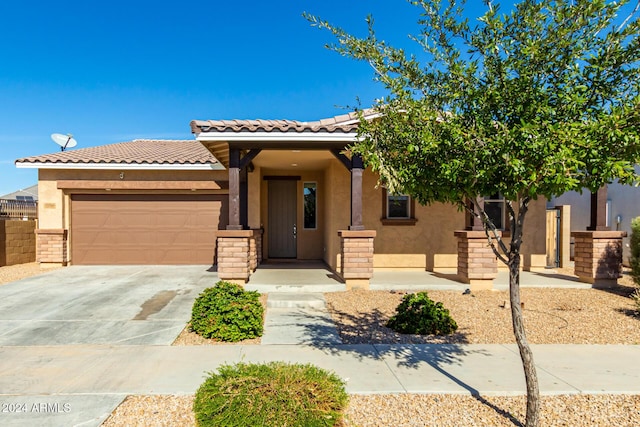 view of front of home with a garage, stucco siding, a tile roof, and concrete driveway