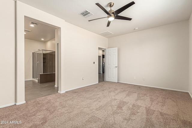 unfurnished bedroom featuring a ceiling fan, visible vents, carpet floors, baseboards, and connected bathroom