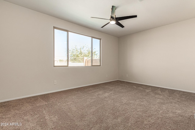 carpeted spare room with ceiling fan