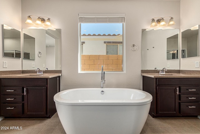 bathroom with a soaking tub, two vanities, a sink, and tile patterned flooring