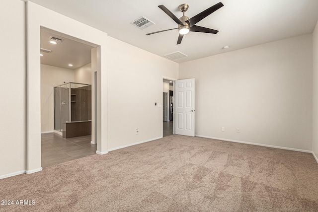 unfurnished bedroom featuring light carpet, ensuite bathroom, and ceiling fan