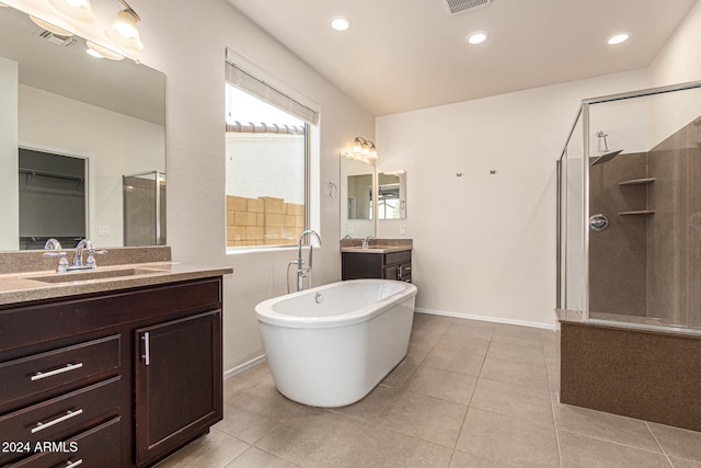 bathroom with vanity, tile patterned flooring, and plus walk in shower