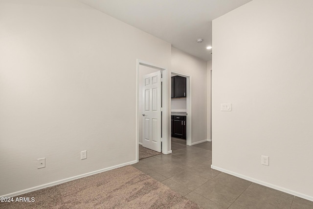 spare room with dark tile patterned floors, recessed lighting, and baseboards