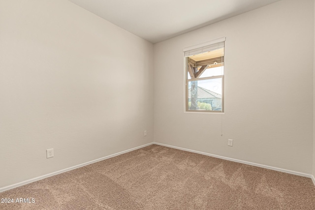 carpeted empty room featuring baseboards