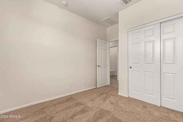 unfurnished bedroom with a closet, baseboards, carpet flooring, and visible vents
