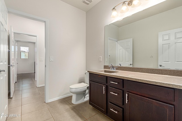 bathroom featuring tile patterned flooring, visible vents, vanity, toilet, and baseboards