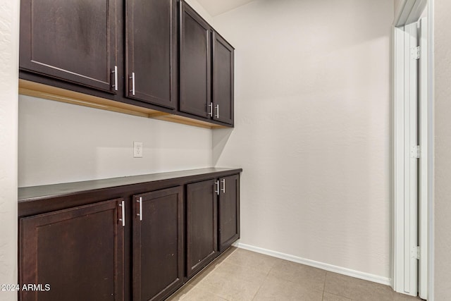 interior space featuring baseboards and light tile patterned flooring