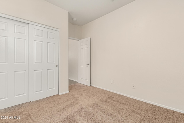 unfurnished bedroom with a closet and light carpet