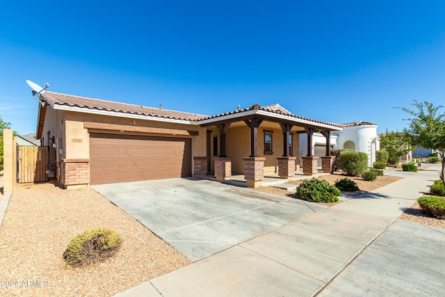 view of front of house featuring an attached garage, stucco siding, driveway, and a tiled roof