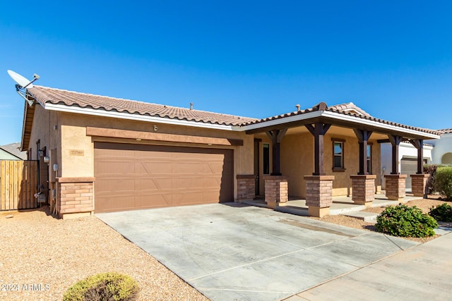 view of front of property featuring concrete driveway, a tiled roof, an attached garage, and stucco siding