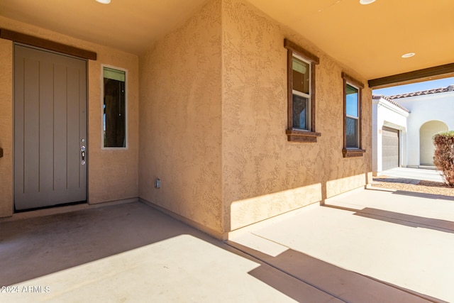 view of exterior entry featuring a patio area