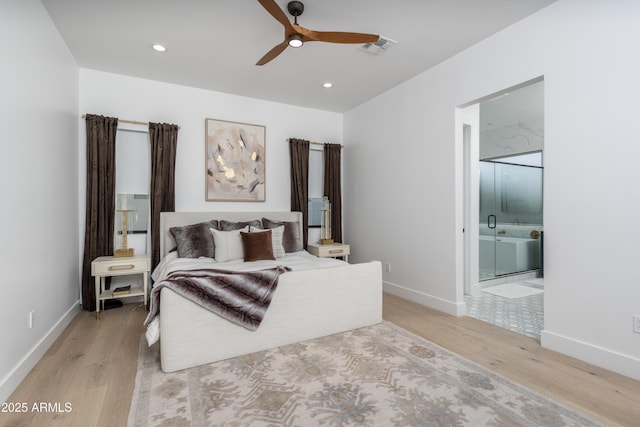 bedroom featuring baseboards, visible vents, light wood finished floors, and ensuite bathroom