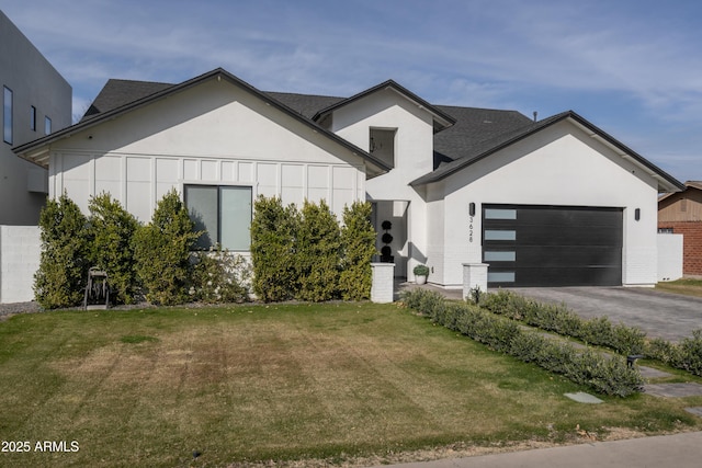 view of front of house featuring a garage, a front yard, driveway, and stucco siding