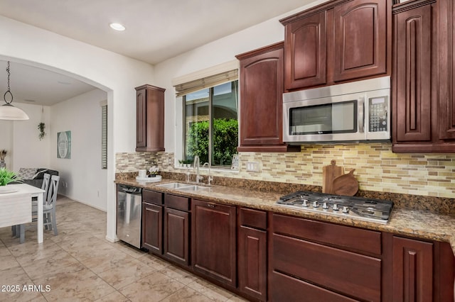3622 E Sparrow Pl, Chandler, AZ 85286 - kitchen with appliances with stainless steel finishes, backsplash, arched walkways, recessed lighting, and dark stone countertops