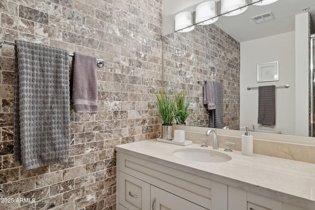 bathroom with tile walls, visible vents, and vanity