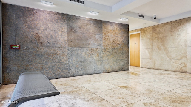 interior space with visible vents and tile walls