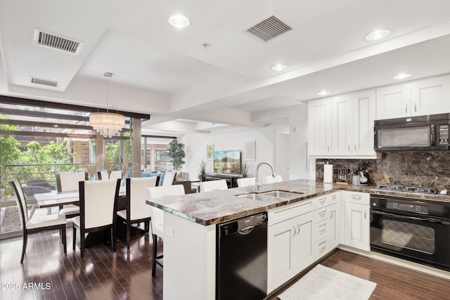 kitchen with black appliances, a sink, and visible vents