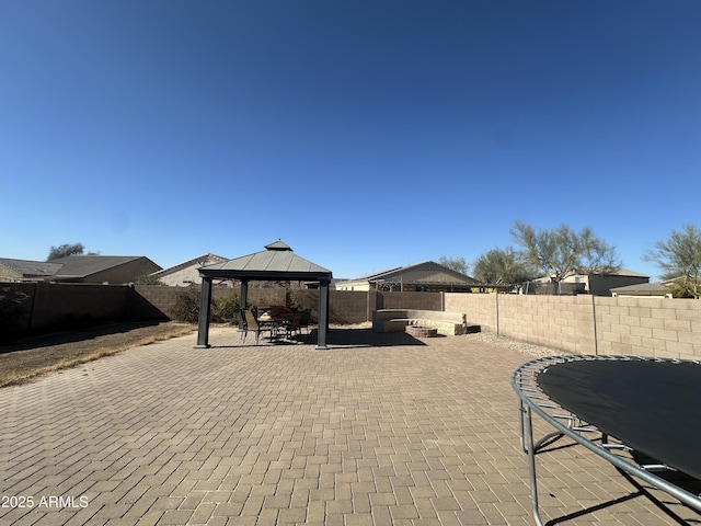 view of patio featuring a trampoline and a gazebo