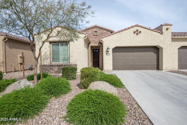 mediterranean / spanish house featuring concrete driveway, an attached garage, a tile roof, and stucco siding