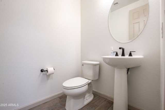 bathroom with visible vents, wood finished floors, toilet, and baseboards