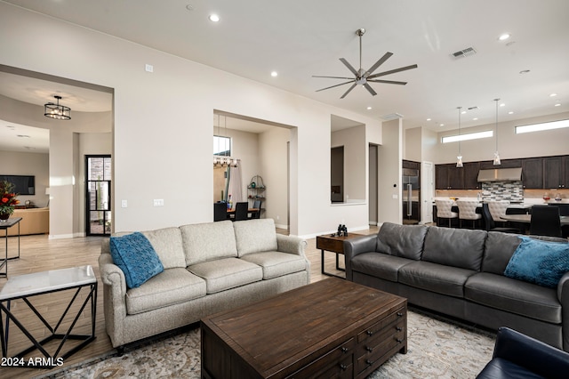 living room featuring light wood-type flooring, a healthy amount of sunlight, and ceiling fan