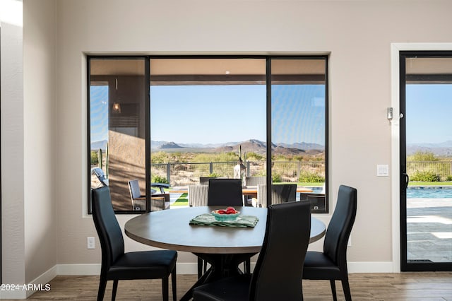 dining area with a healthy amount of sunlight, hardwood / wood-style floors, and a mountain view