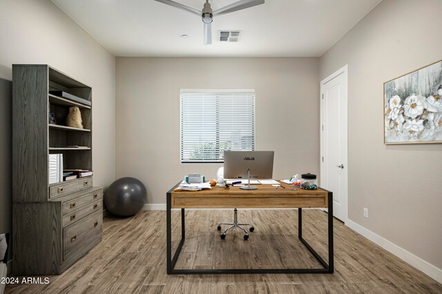 home office with light hardwood / wood-style flooring