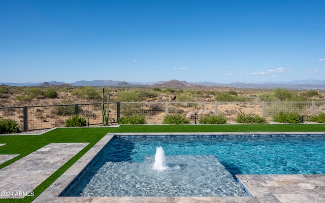 view of pool with a yard, a mountain view, and pool water feature