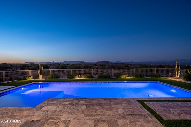 pool at dusk featuring a mountain view