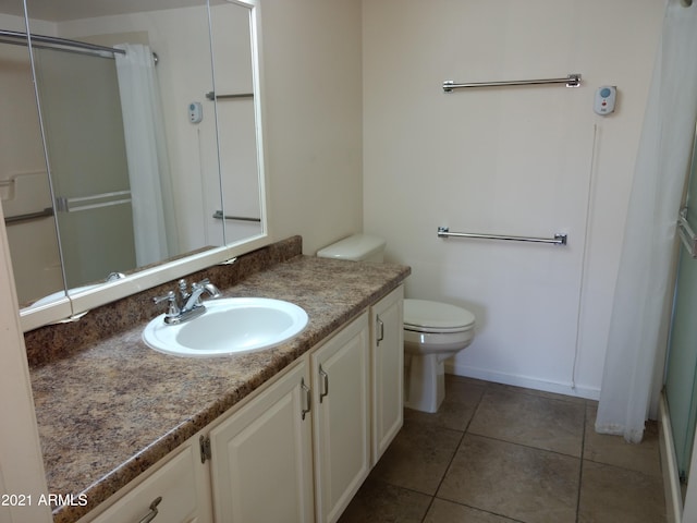 bathroom featuring walk in shower, tile patterned floors, toilet, and vanity